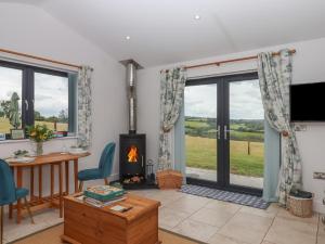 a living room with a fireplace and a table and chairs at The Pennymoor in Tiverton