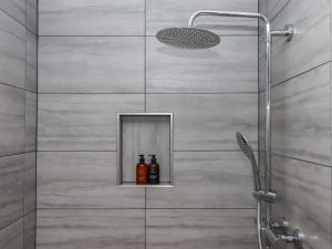 a shower with a glass door with bottles on a shelf at The Pennymoor in Tiverton +38 photos