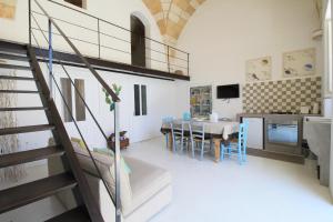 ein Wohnzimmer mit einer Treppe und eine Küche in der Unterkunft Le Bijou in Gagliano del Capo