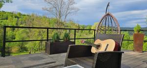 a guitar sitting on a chair on a deck at Forest House Doftana in Teşila