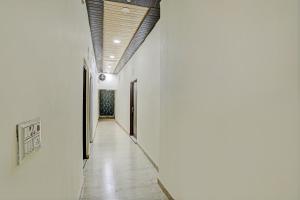 un pasillo con paredes blancas y techo de madera en Hotel O Mayur Bulandshahr, en Bulandshahr
