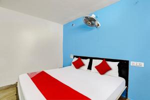 Un dormitorio con una cama con una pared azul y un foco. en Hotel O Mayur Bulandshahr, en Bulandshahr