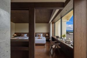 ein Schlafzimmer mit einem Bett und einem Schreibtisch mit einem Fenster in der Unterkunft Sunny Aerie丨 Golden Peak Resort in Baisha + 91 Fotos