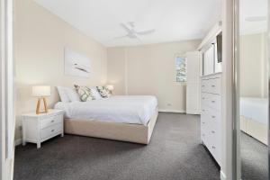 a white bedroom with a large bed and a dresser at Park View Apartment in Mantra Salt Resort by uHoliday - 2BR, 1BR and Hotel Room configurations available in Kingscliff