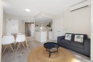 a living room with a couch and a table at Park View Apartment in Mantra Salt Resort by uHoliday - 2BR, 1BR and Hotel Room configurations available in Kingscliff +9 photos