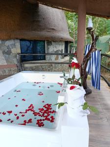 a white table with red flowers in a vase at Dream Cliff Mountain Resort in Haputale