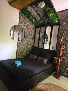 a room with a black couch against a wall at Le reflet exotique in Saint-Pierre