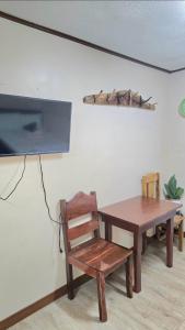 a wooden table and a wooden chair and a tv at Zone Vill Baguio Condo Transient Unit 505 by Dei Gratia in Baguio