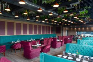 a dining room with purple chairs and tables at Clarks Inn Basti in Basti