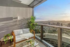 a balcony with a couch and a view of the city at Iconic Views - Queen's Wharf 1BR - Casino & South Bank in Brisbane