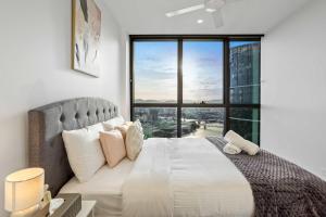a bedroom with a large bed with a large window at Iconic Views - Queen's Wharf 1BR - Casino & South Bank in Brisbane