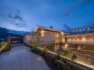 ein Haus mit einem Weg, der nachts dorthin führt in der Unterkunft Sunny Aerie丨 Golden Peak Resort in Baisha