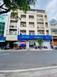 een groot wit gebouw met een blauw bord erop bij Vina Home in Ho Chi Minh-stad