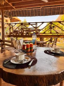 a wooden table with two cups and plates on it at Jumanji B&B in Kinyasini +19 photos