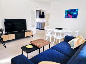 a living room with a blue couch and a tv at Mare`s House Apartments with Pool in Karlobag
