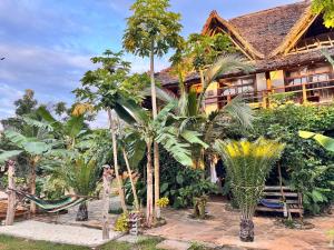 a house with palm trees in front of it at Jumanji B&B in Kinyasini