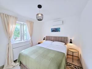 a white bedroom with a large bed and a window at Mare`s House Apartments with Pool in Karlobag +36 photos