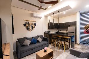 a living room with a couch and a kitchen at Tulum Escape - Private Hot Tub, Steps to Free Beach in Tulum