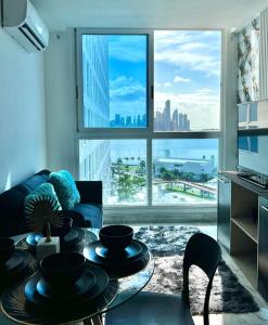 a living room with a couch and a large window at Vista al Mar y Ciudad de 2 habitaciones in Panama City