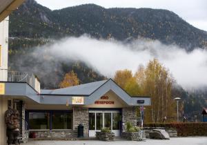 a building with clouds in front of a mountain at Motell Nor-Kro in Bromma