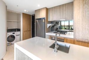a kitchen with a sink and a refrigerator at 108 Flinders - Stunning Views & Prime Location in Melbourne