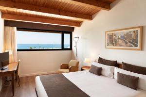 a bedroom with a bed and a desk and a window at Estela Barcelona in Sitges +58 photos