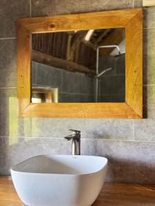 a white sink in a bathroom with a mirror at Jumanji B&B in Kinyasini