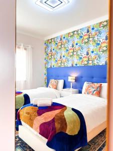 2 letti in una camera da letto con un murale di Golden Palm Condo by BeCherish ad Albufeira Altre 23 foto