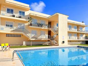 a building with a swimming pool in front of a building at Golden Palm Condo by BeCherish in Albufeira