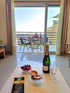 a bottle of wine and a bowl of fruit on a table at AlbufeiraOrada BlueSky by Be Cherish in Albufeira