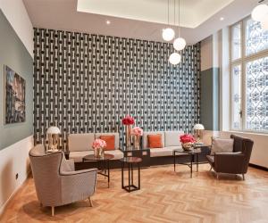 a living room with a couch and tables and chairs at DoubleTree By Hilton Trieste in Trieste