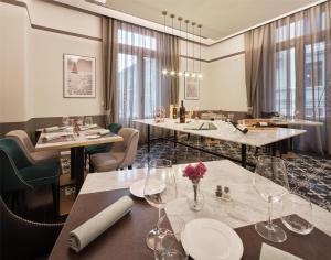 a restaurant with tables and chairs with wine glasses at DoubleTree By Hilton Trieste in Trieste