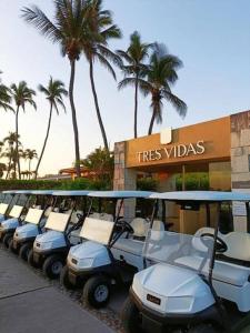 a row of golf carts parked in front of a tree villas at Exclusive Oceanfront Apartment Beach access in Acapulco