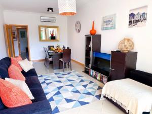 een woonkamer met een bank en een tv bij AlbufeiraOrada Garden by Be Cherish in Albufeira