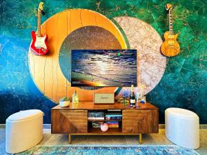 un soggiorno con una tv e due chitarre sul muro di Lisbon Prestige River View Condo by BeCherish a Lisbona