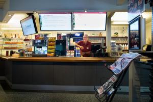 a woman standing behind the counter of a coffee shop at Motell Nor-Kro in Bromma