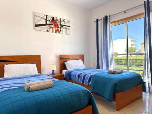 a bedroom with two beds and a window at Modern Ocean, Garden & Pool view Condo by BeCherish in Albufeira