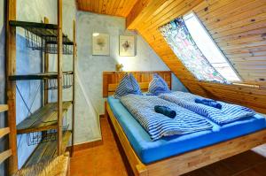 a blue bed in a room with a window at Chalupa v Meziluzi in Meziluží