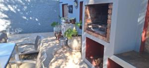 a patio with a fireplace and a table and chairs at Chrysantimum Guest Apartment in Thabazimbi