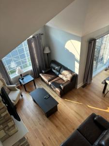a living room with a leather couch and a table at In-ground pool - Spacious condo - Horizons in Saint-Sauveur-des-Monts +12 photos