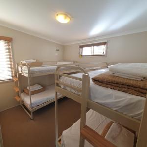 una camera con due letti a castello e due finestre di Pleasurelea Tourist Resort & Caravan Park a Batemans Bay Altre 81 foto