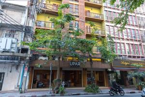 a building on a street with a tree in front of it at Elite Home stays by UPAR, Silom in Bangkok