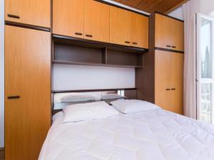 een slaapkamer met een groot bed met houten kasten bij Apartments Anka - One-Bedroom Apartment with Balcony and Sea View in Trsteno