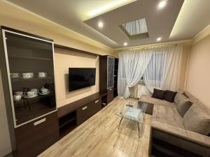 a living room with a couch and a flat screen tv at GiT Home in Kętrzyn