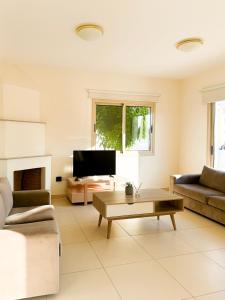 a living room with a couch and a coffee table at Villa Merope Irena 1 in Polis Chrysochous +32 photos