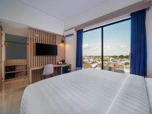 Un dormitorio con una cama grande y una ventana grande. en Aston Inn Lumajang - East Java, en Lumajang 37 fotos más