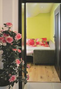 a bedroom with a bed and a mirror and roses at Apartament Rajska in Gdańsk