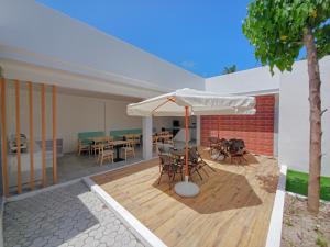 a patio with a table and chairs and an umbrella at Avenly Omadhoo in Omadhoo