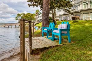 Dos sillas azules sentadas en una terraza de madera junto al agua. en 3BR Townhome Steps to Bay - Pool & Beach Gear, en Navarre
