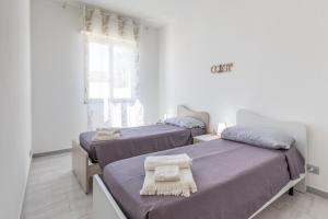 a bedroom with two beds and a window at Villa Primavera in Marina di Modica